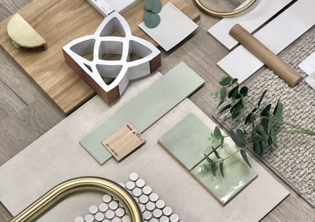 An assortment of interior design samples including color swatches, tiles, and decorative elements arranged on a table for selection.